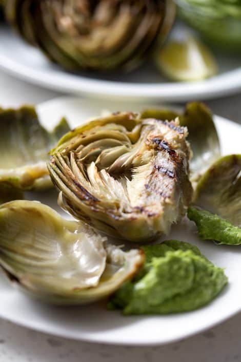 Grilled-Artichokes-with-Cilantro-Avocado-Dip-32sm midway through eating an artichoke with green dip