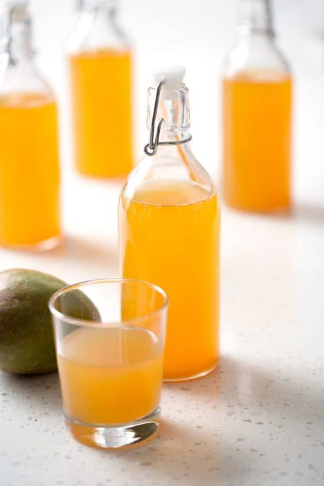 Mango-Kombucha-46sm bottle of mango kombucha tea with mango on white background