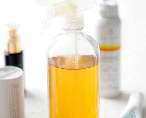 bottle of homemade household cleaner and other non-toxic products on white background