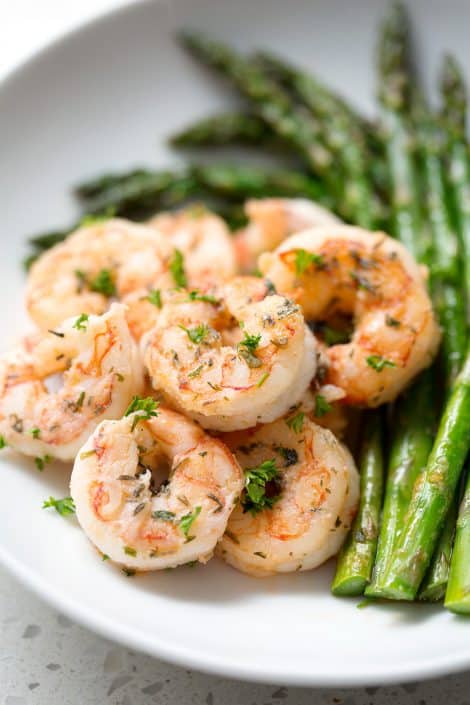 Pan-Fried-Herb-Shrimp-17sm plate of seasoned shrimp with asparagus on white background