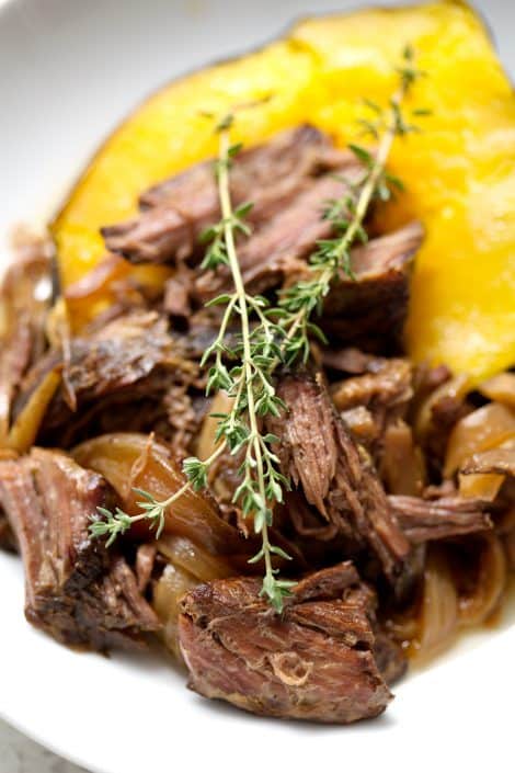 Slow-Cooker-AIP-Shredded-Beef-32sm shredded beef on acorn squash with sprigs of thyme