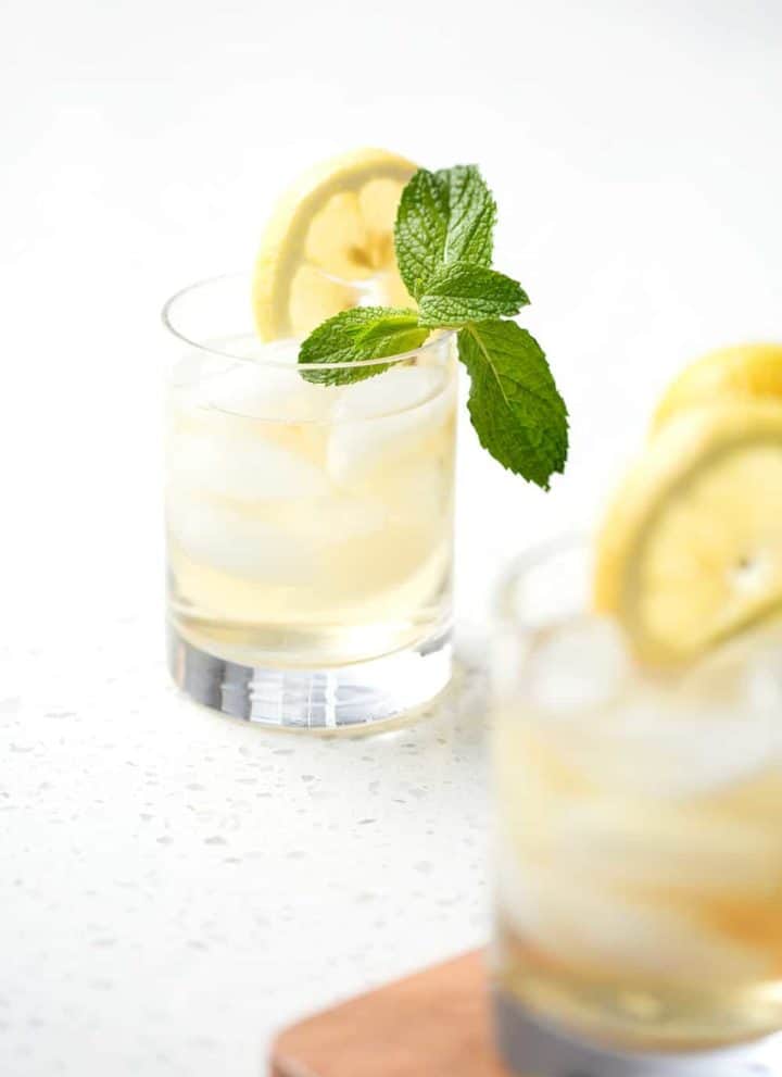 glass of green tea on which background with slice of lemon and mint sprig