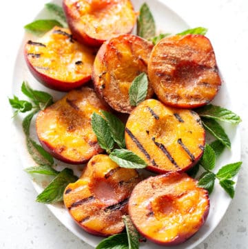 platter of grilled peaches garnished with mint