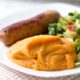 mashed sweet potatoes on white plate with sausage