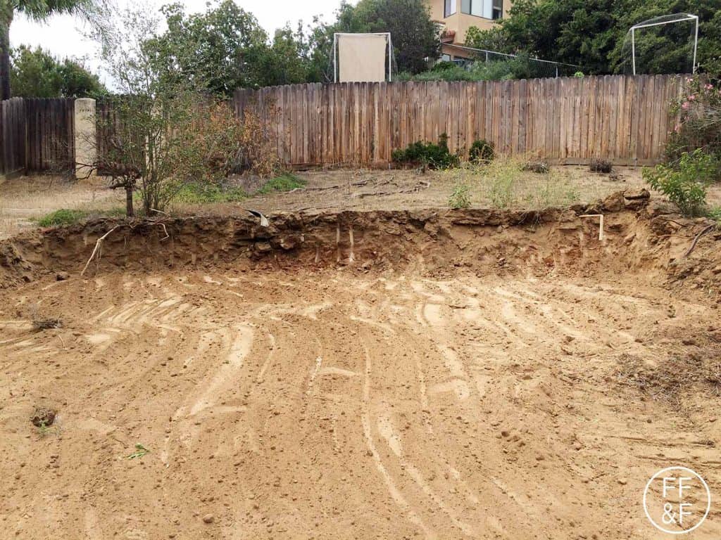 Grading the backyard. It's on a slope and we have to cut into the hill to create a flat space for a sitting area. #BethHomeProject 