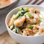 shrimp and basil in a bowl with chopsticks in the background