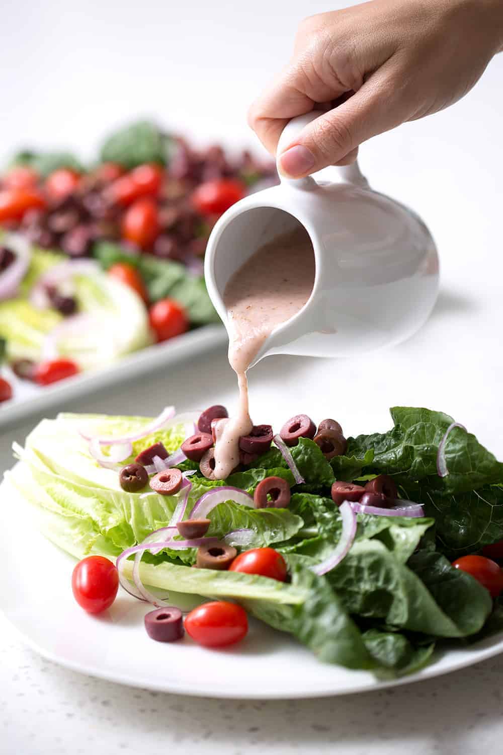 A simple recipe for an autoimmune protocol approved Mediterranean Salad. Romaine lettuce is the base for lots of onions, tomatoes, kalamata olives and homemade Mediterranean Salad Dressing. This recipe is allergy friendly (gluten, dairy, shellfish, nut, egg, and soy free) and suits the autoimmune protocol (AIP) and paleo diets.