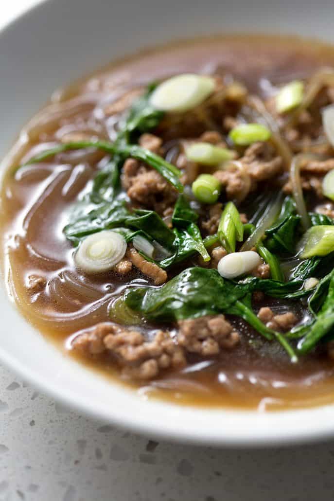 soup with greens in white bowl