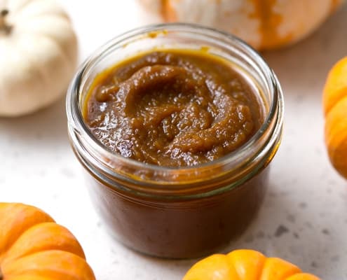 pumpkin butter on white background with mini pumpkins