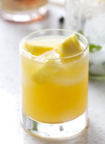 glass filled with juice and pineapple chucks