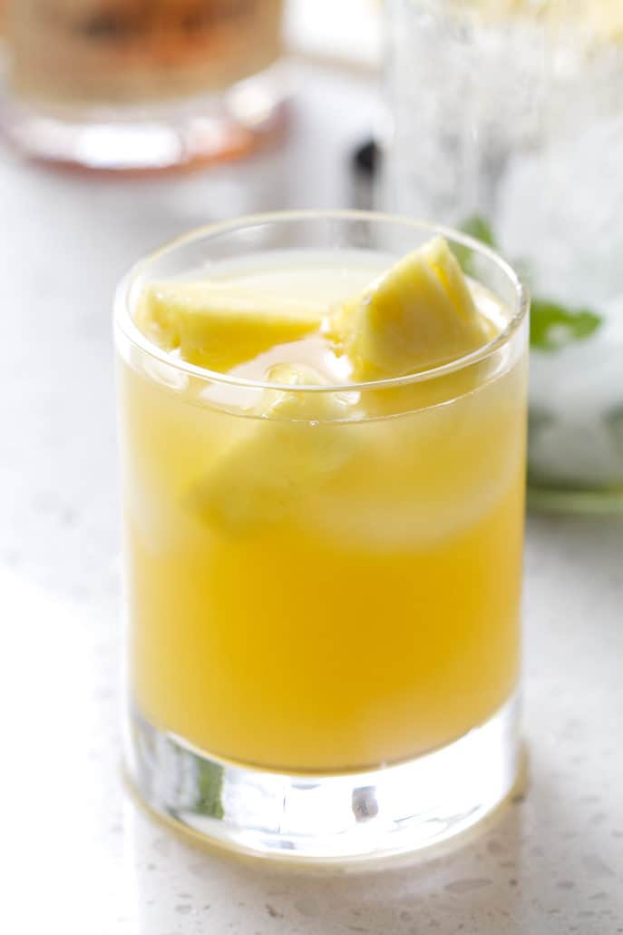 glass filled with juice and pineapple chucks