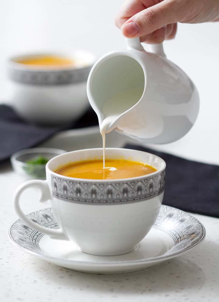 pouring cream into carrot ginger soup