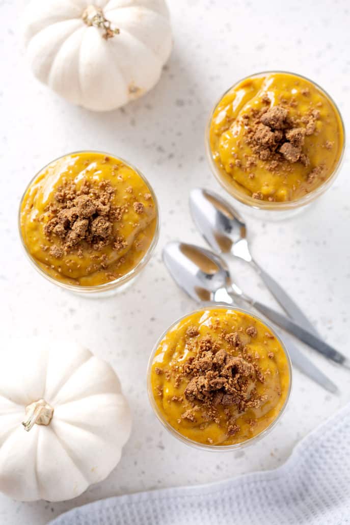 pumpkin pudding cups from above with pumpkins and spoons