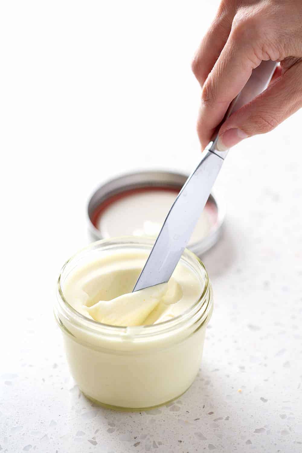 mason jar filled with egg free mayo with knife scooping it out