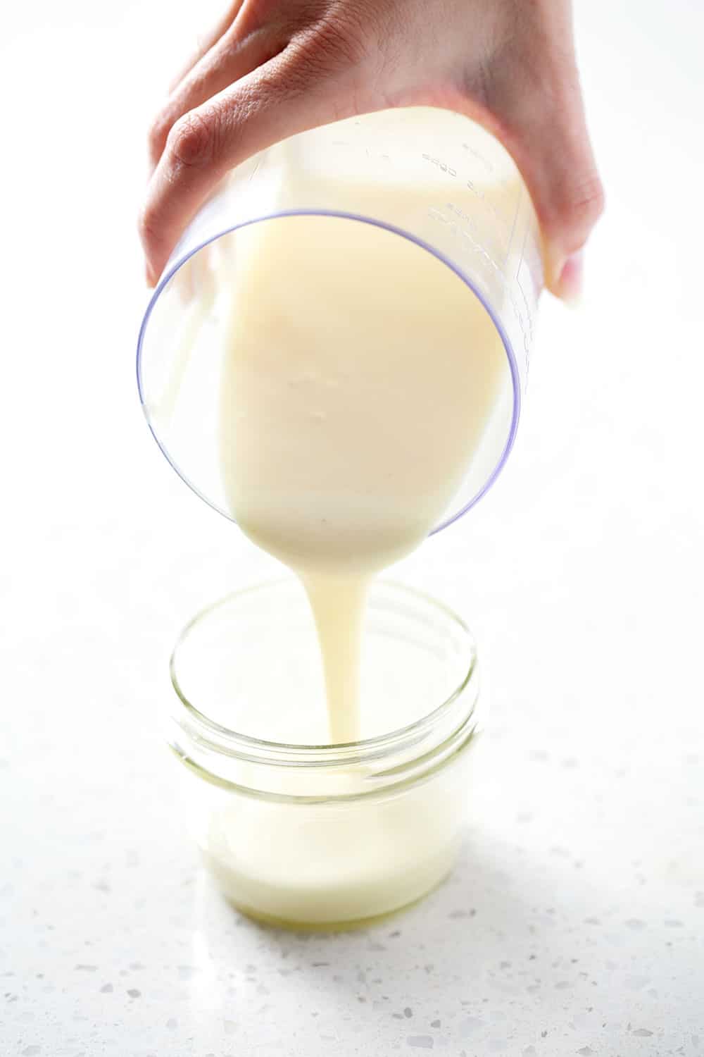 pouring aip mayo (egg free mayoo recipe) into mason jar