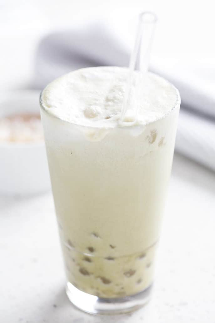large glass with straw of AIP Matchs Bubble Tea with small bowl of boba