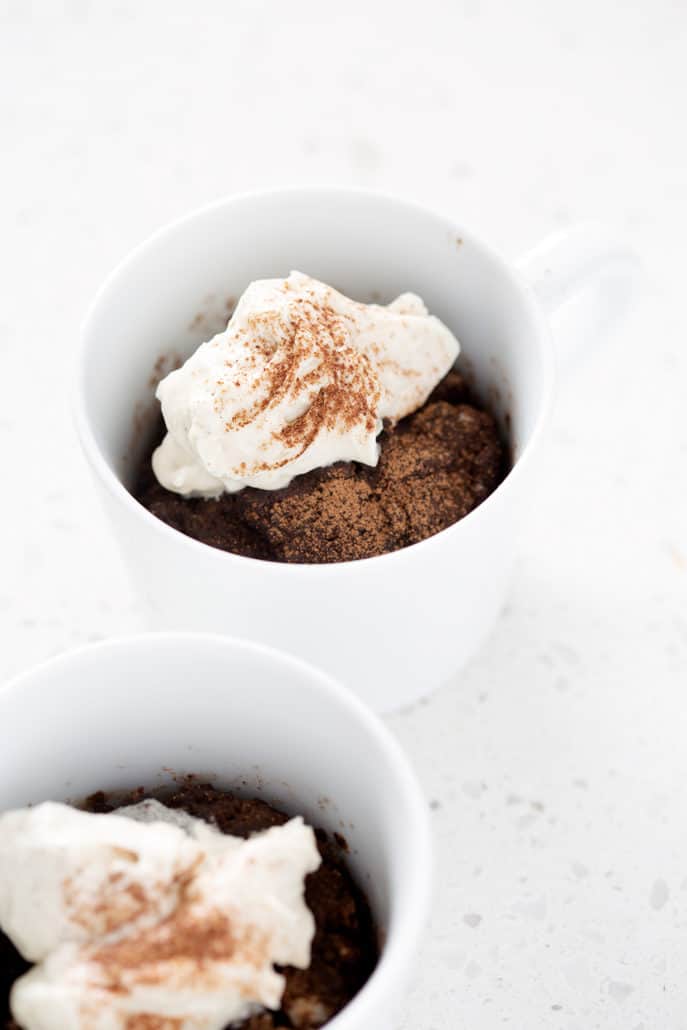 white mug with AIP Chocolate Cake and frosting sprinkled with carob