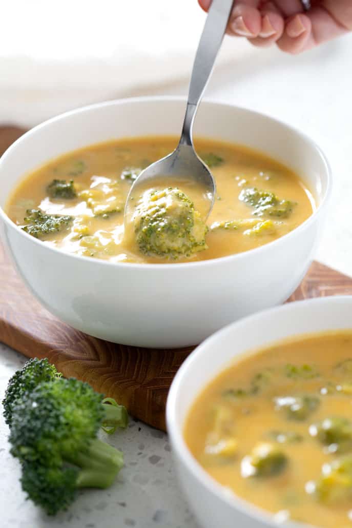 spooning up AIP Broccoli Cheese Soup out of bowl